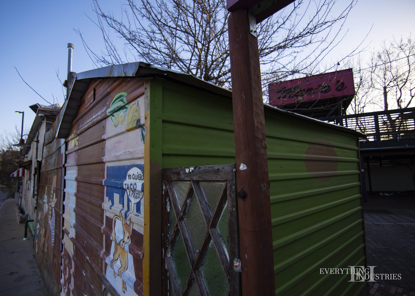 A shed at Maria's Taco Express with art painted on it. Maria's Sign in the background