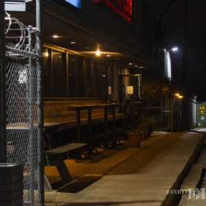 A view down the front of Musiclab towards a dumpster with graffiti